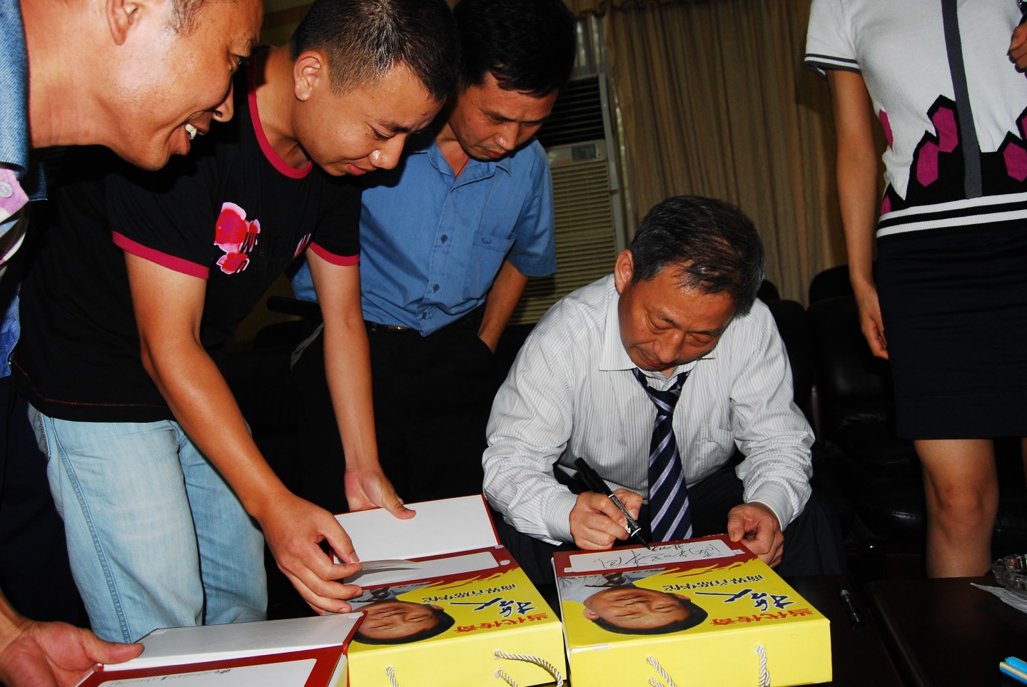 Yan signs a book he wrote on Confucius-like aphorisms for business.