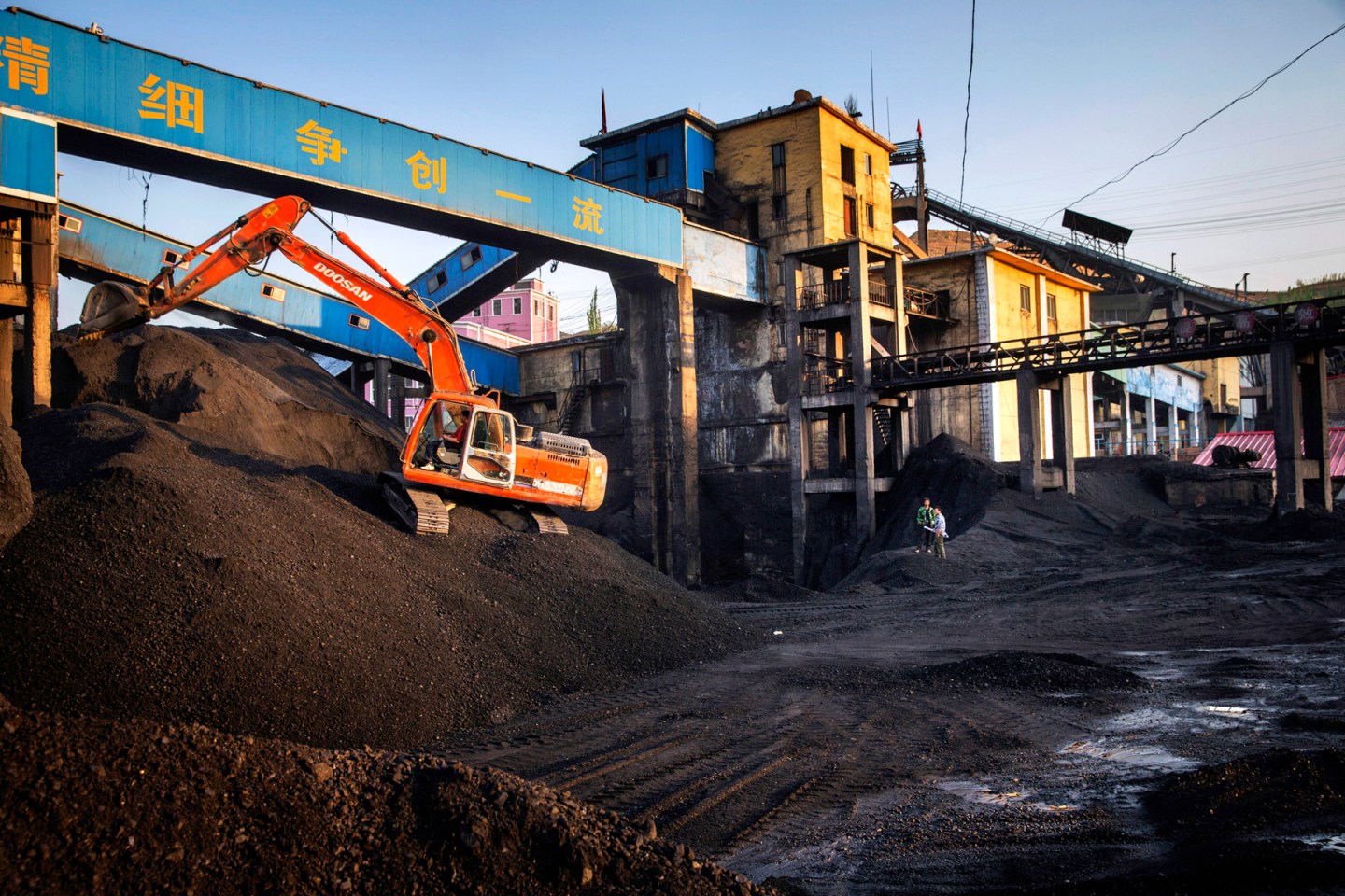 Workers are seen in a coal yard