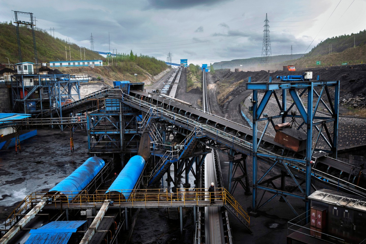 A worker looks over a conveyor moving coal through the An Tai Bao open pit coal mine