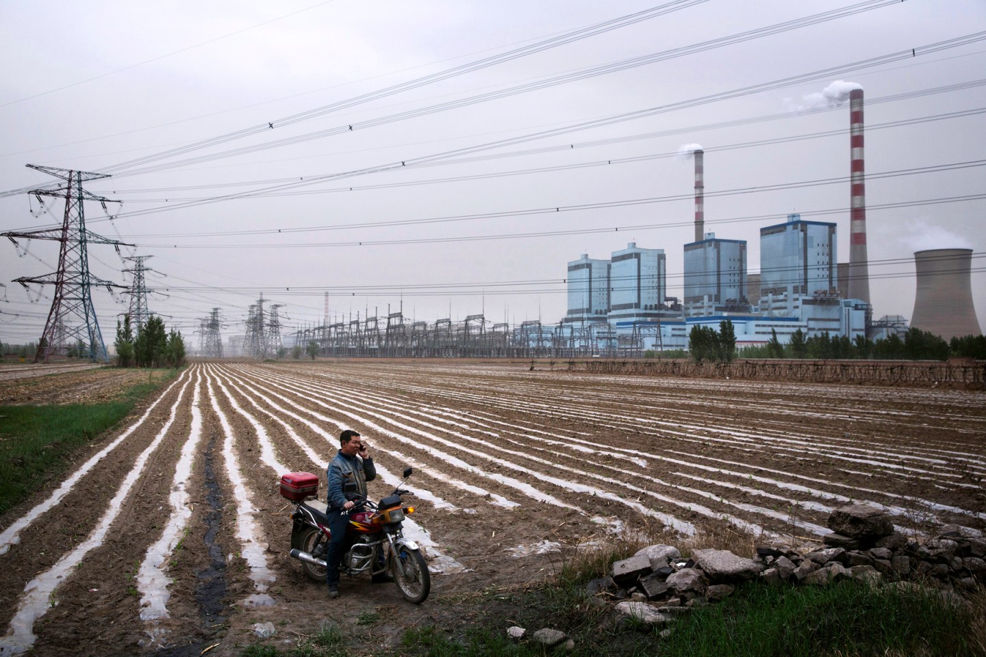 A farmer talks on the phone after working in the fields