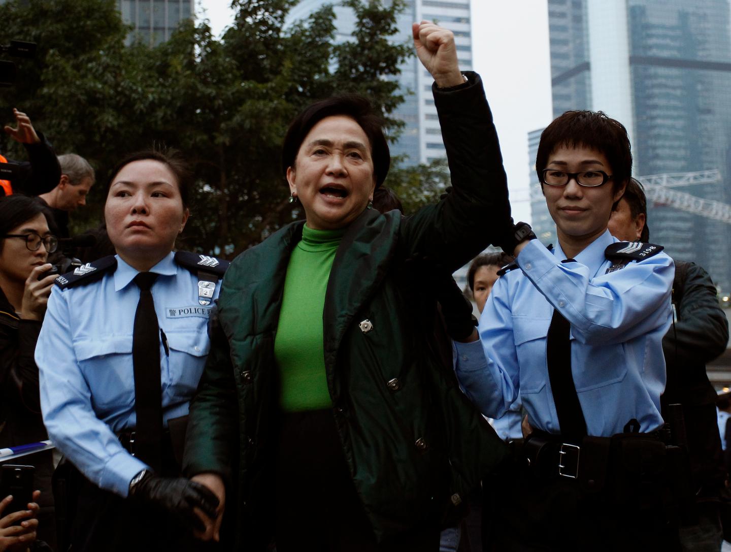 Pro-democracy lawmaker Emily Lau chants slogans as she is taken away by the police outside the government headquarters in Hong Kong