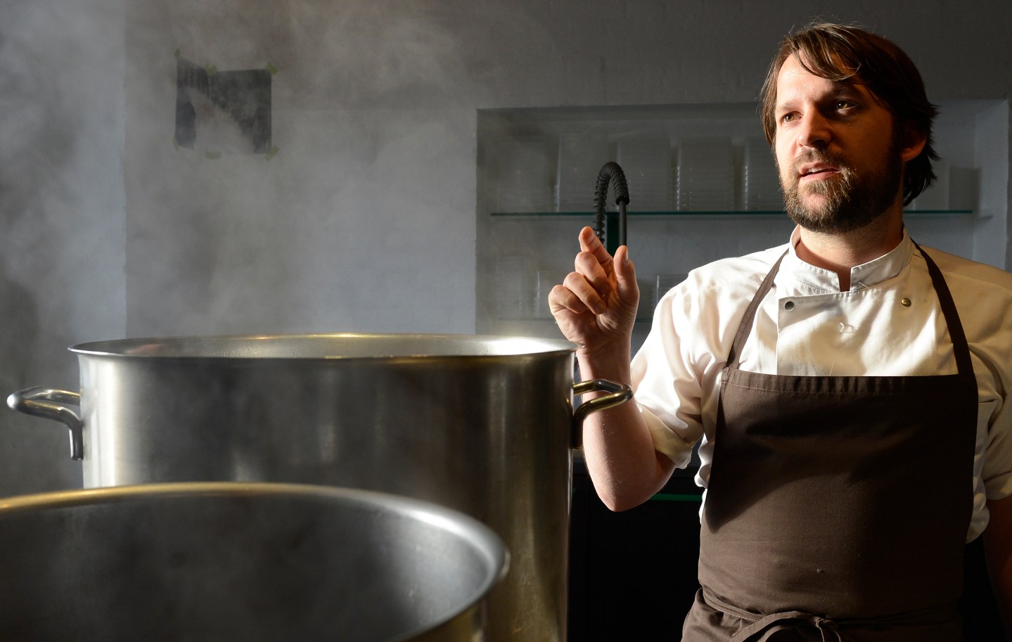 Redzepi, chef and co-owner of the restaurant Noma, talks with his employees in a test kitchen in his restaurant in Copenhagen