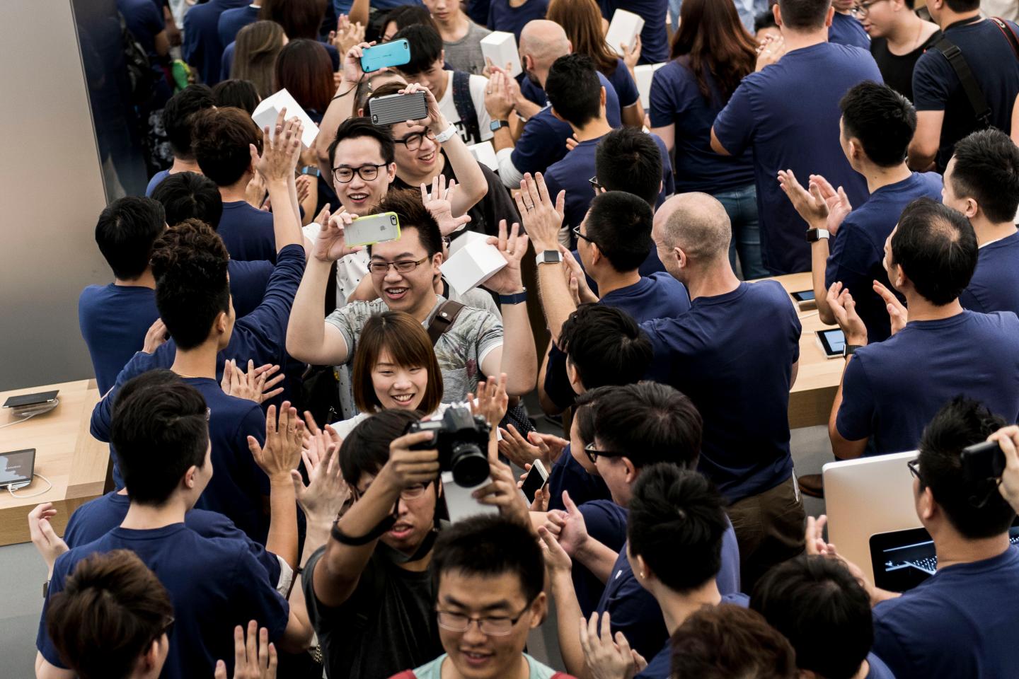 Employees welcome customers into Apple Inc.'s new Canton Road store in the Tsim Sha Tsui district of Hong Kong, China, on Thursday, July 30, 2015. Apple opens its forth store in Hong Kong today. Photographer: Xaume Olleros/Bloomberg