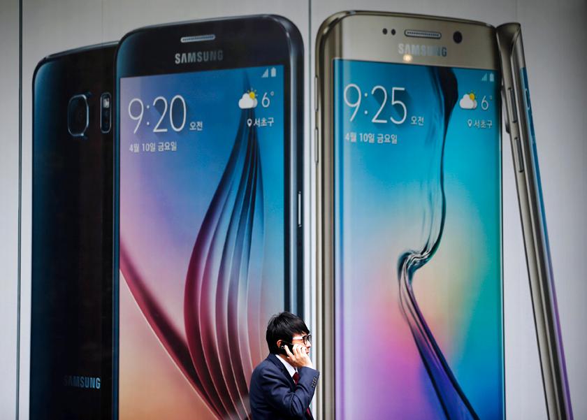 A man talks on a phone in front of a giant advertisement promoting Samsung Electronics' new smartphone Galaxy S6 in Seoul