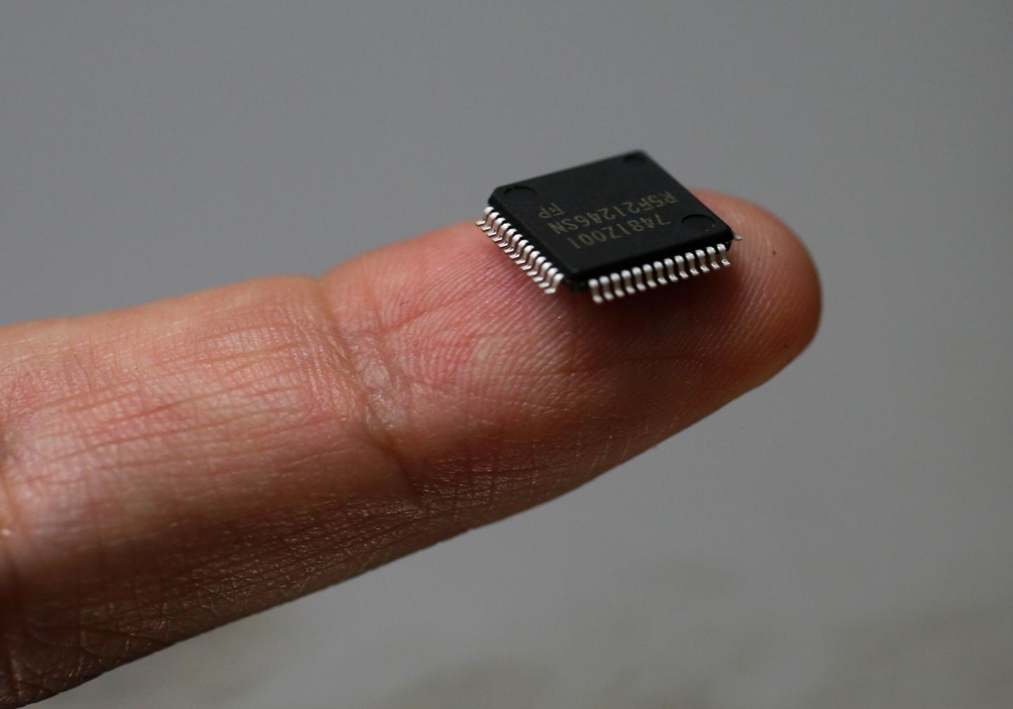 A Renesas Electronics Corp's microcontroller chip sits on a finger in this illustrative photograph taken in Tokyo