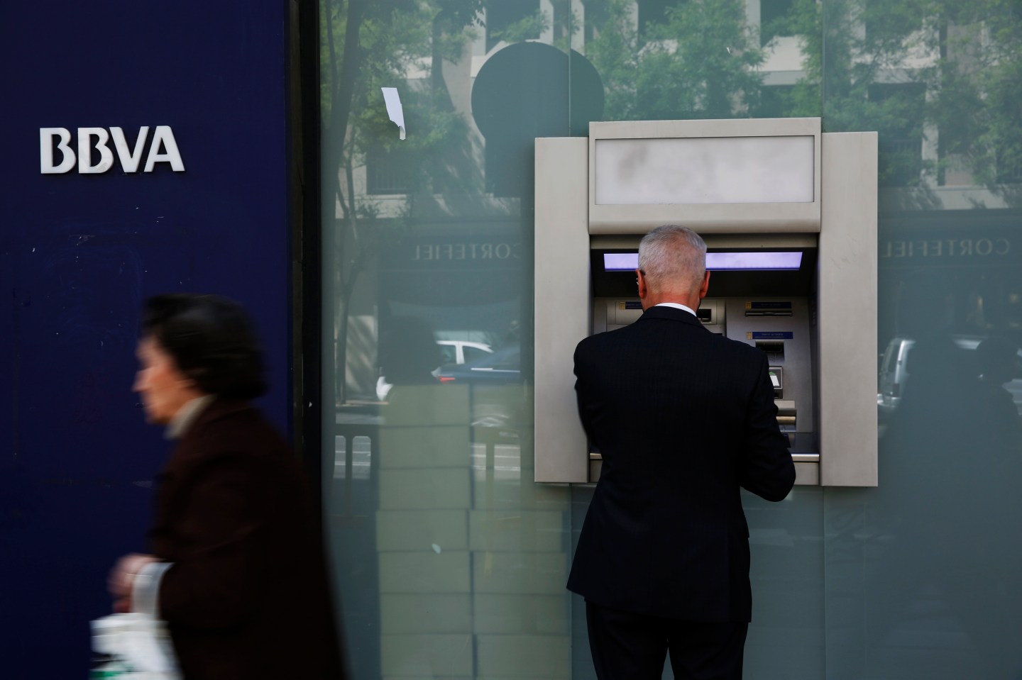 A man uses an ATM machine at a BBVA bank branch in Madrid