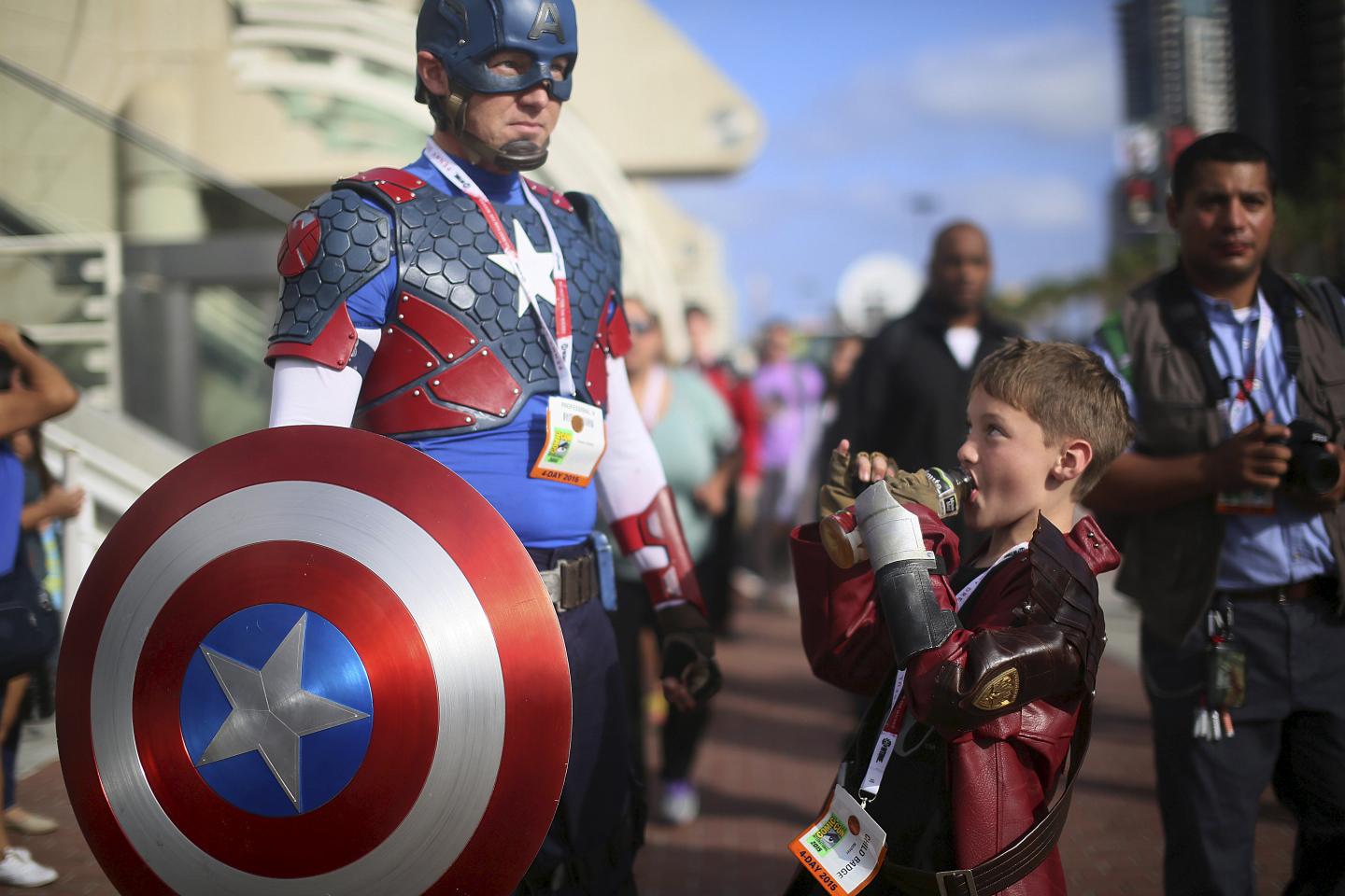 Shawn Richter shows his Captain America costume while his son Gavin looks on during the 2015 Comic-Con International in San Diego