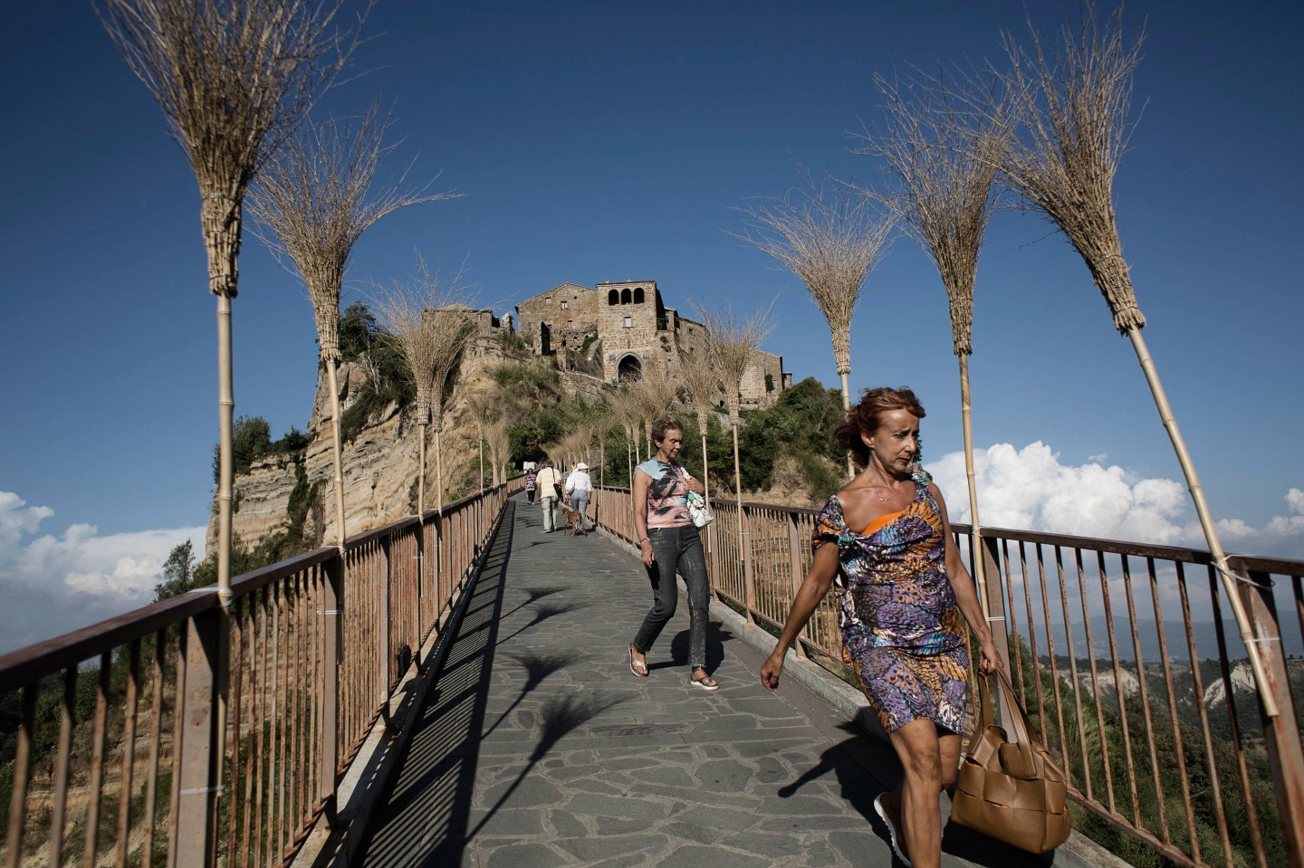 Visitors walk down the footbridge that leads to Civita di Bagnoregio, Italy.