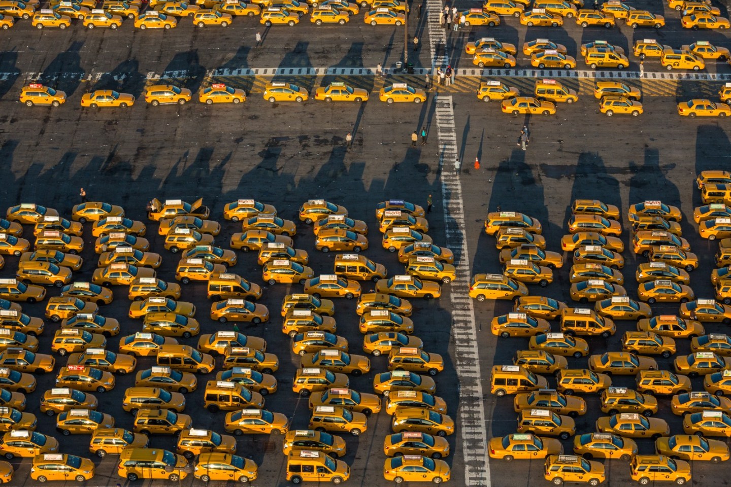 The rate of fare for trips between Manhattan and JFK International Airport, “is $52.00 plus any tolls using Rate Code 2 on the meter. A NY State Tax Surcharge of $0.50 will be added to each trip.” According to the 2014 Taxi Factbook, people traveling to and from the city’s airports represent 5 percent of all taxi trips, and about 10 percent of all passengers arriving at and departing from JFK use a taxi. Here, taxis wait in JFK’s Central Taxi Hold lot for a call to one of the terminals.