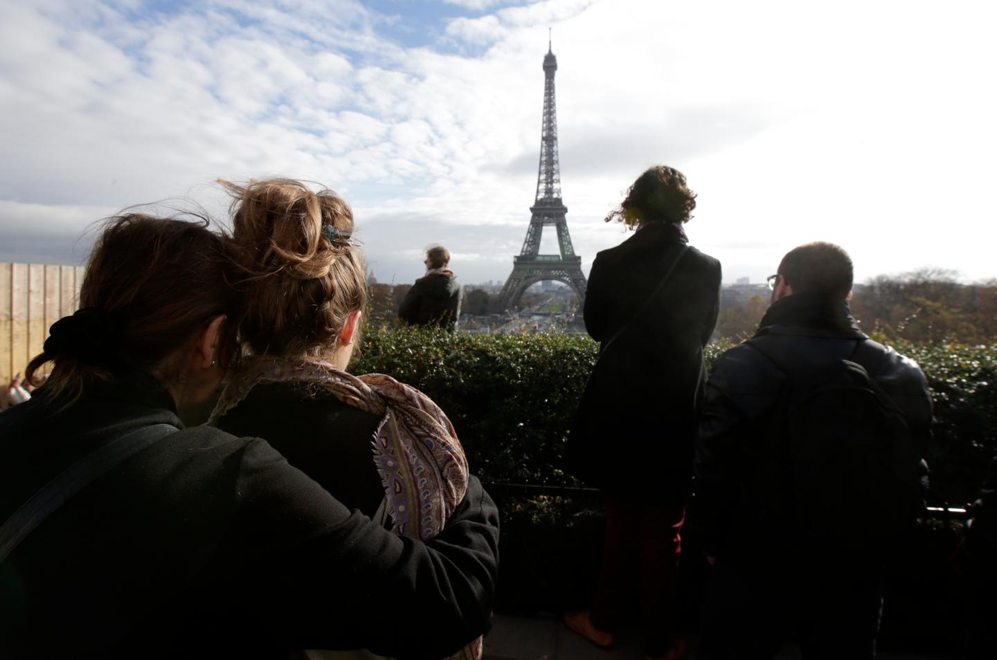 People observe a minute of silence at the Trocadero in front the Eiffel Tower to pay tribute to the victims of the series of deadly attacks on Friday in Paris