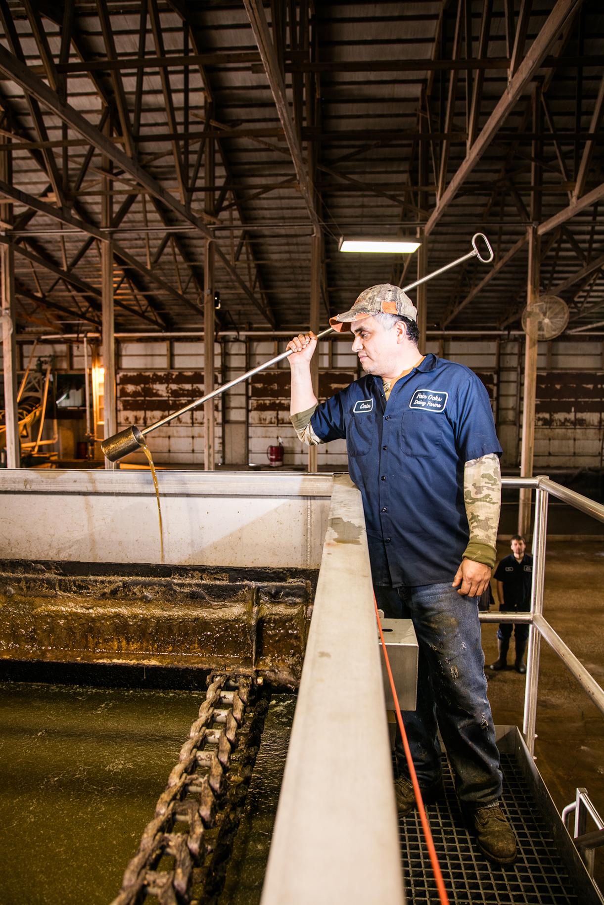 Carlos Hernandez, a plant operator, checks water clarity in a seperation tank at Fair Oaks Dairy in Fair Oaks, Ind., on January 7, 2016.