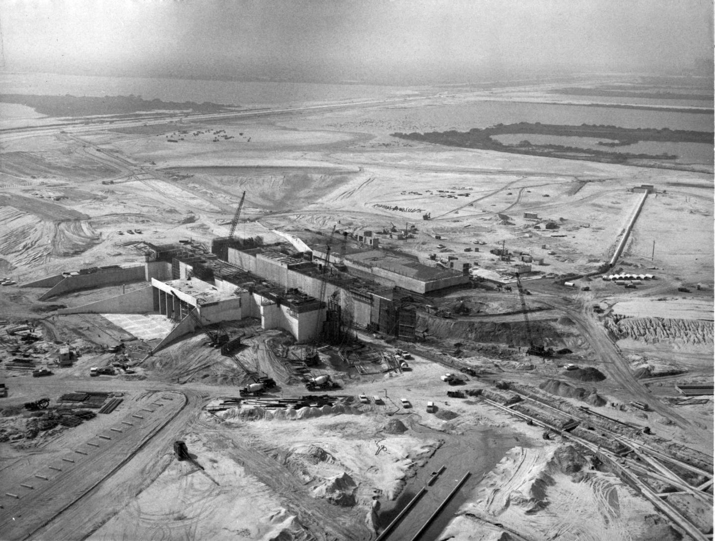 Facing southwest, this aerial view depicts early construction of Launch Pad 39A, one of two launch sites built for the Apollo Saturn V moon rocket. Each site had an eight-sided polygon and measured 3,000 feet across. The pad had a 390-foot-by-325-foot reinforced concrete hardstand standing 48 feet above sea level. The flame trench in the center held a 700,000-pound flame deflector during launch operations. Image credit: NASA Nov. 2, 1965