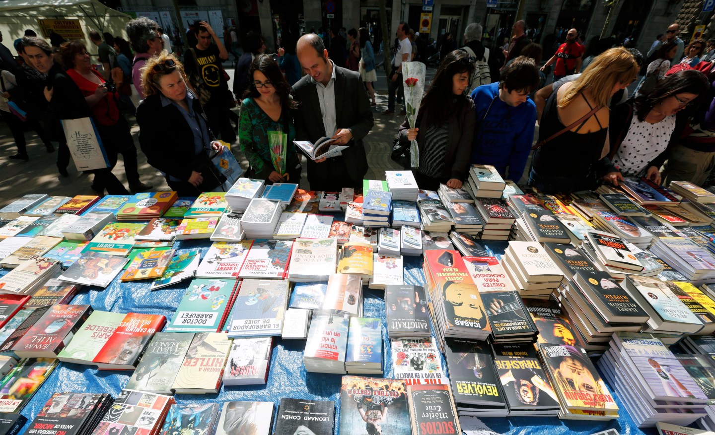 People look books in a stand at Las Ramblas street during traditional Sant Jordi's day celebrations in Barcelona