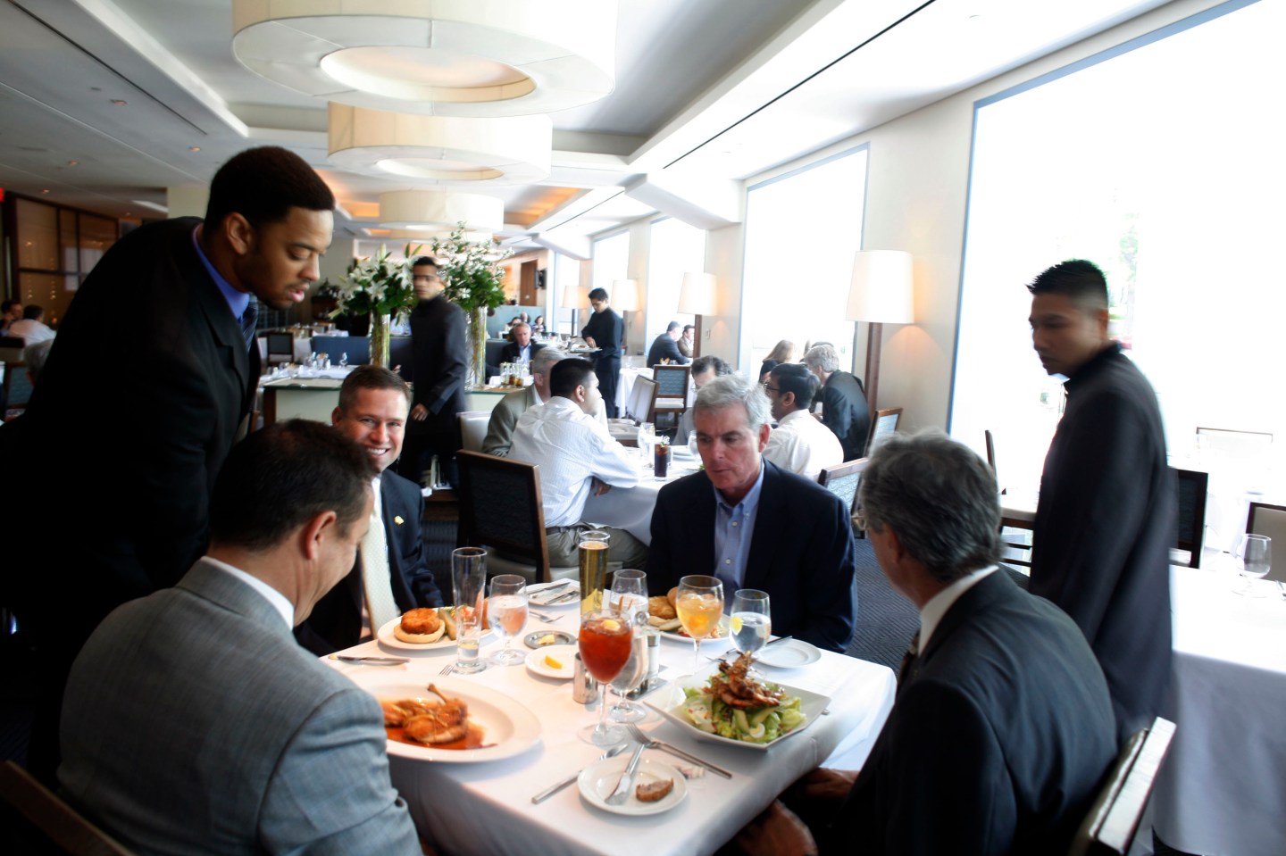 A waiter serves lunch entrees to patrons at Charlie Palmer S