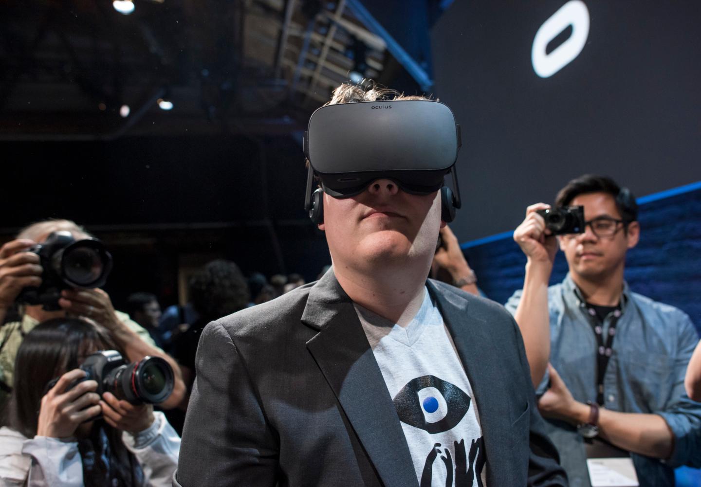 Inc. and creator of the Oculus Rift, demonstrates the new Oculus Rift headset to the media during the Oculus VR Inc. "Step Into The Rift" event in San Francisco, California, U.S., on Thursday, June 11, 2015. Facebook Inc.'s Oculus virtual-reality headsets will work with Microsoft Corp.'s Windows 10 and use the software maker's wireless Xbox game controller. Photographer: David Paul Morris/Bloomberg *** Local Caption *** Palmer Luckey