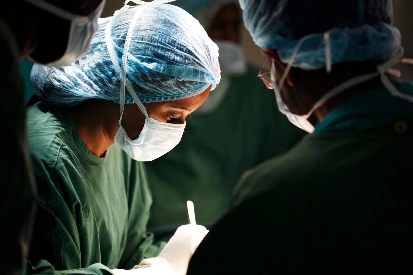 Female surgeon and her assistants operating on patient.