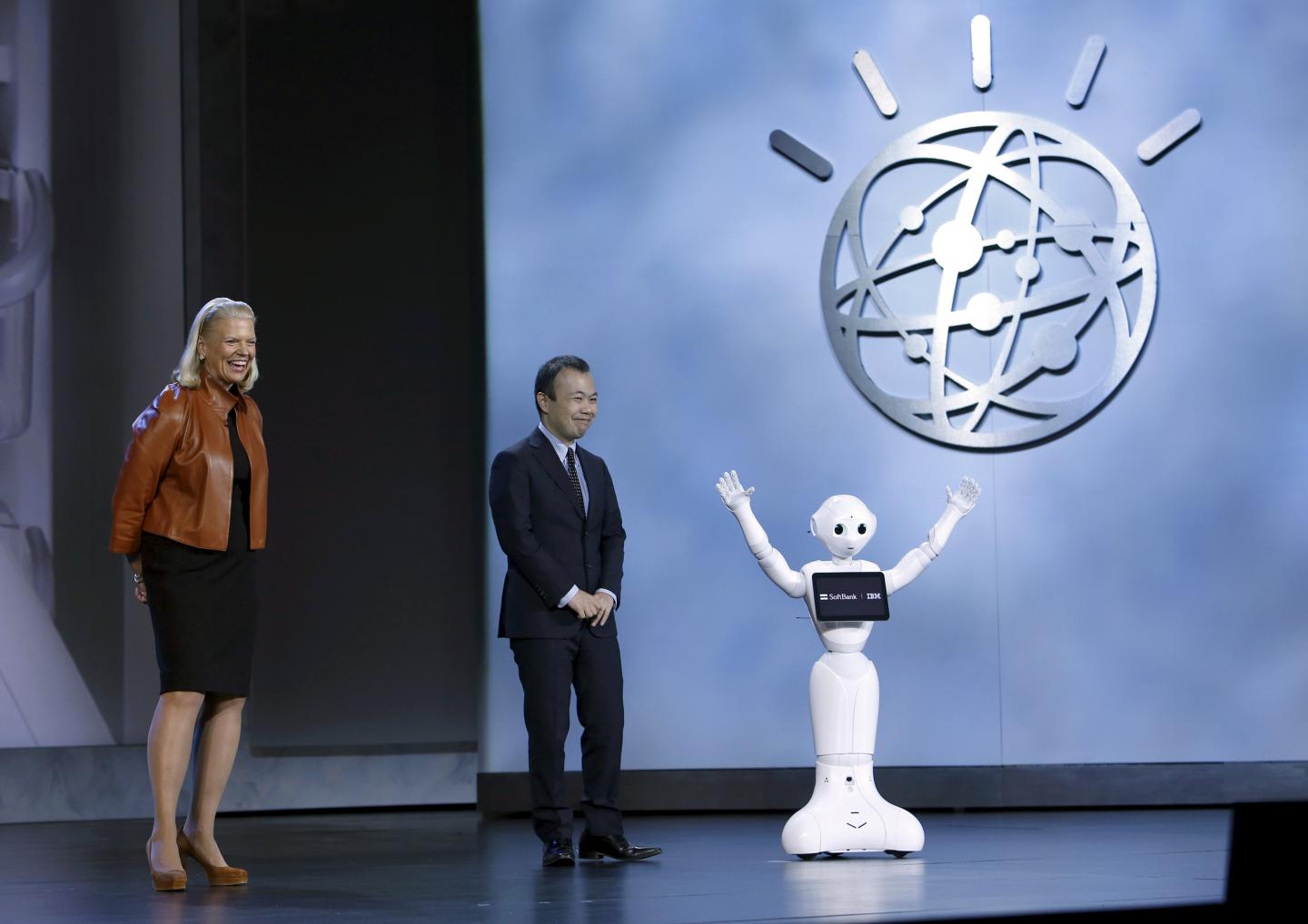 IBM's Rometty and SoftBank Robotics' Yoshida stand near SoftBank's robot Pepper as it waves to the audience during an IBM keynote address at the 2016 CES trade show in Las Vegas