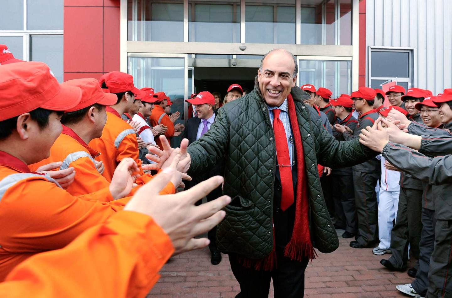 Kent greeting employees at a bottling plant in China's Liaoning province.