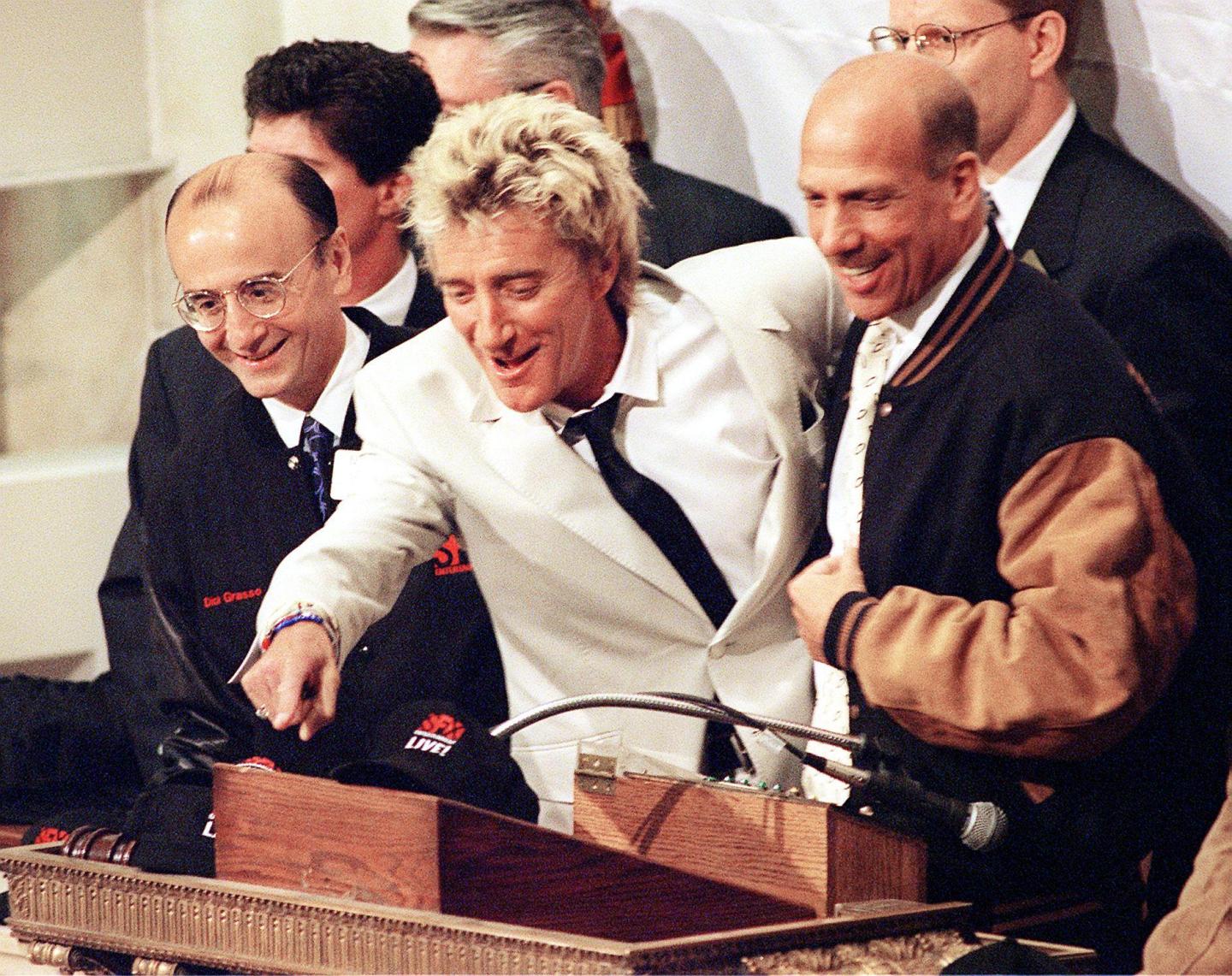 Rock musician Rod Stewart (C) points to someone on