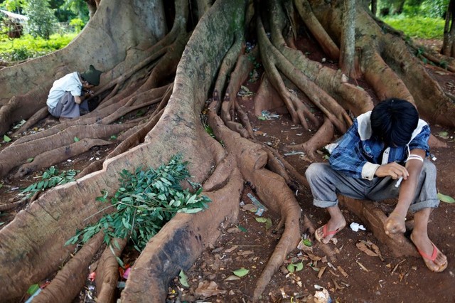 Men inject heroin into their arms along a street in Man Sam, northern Shan state, Myanmar