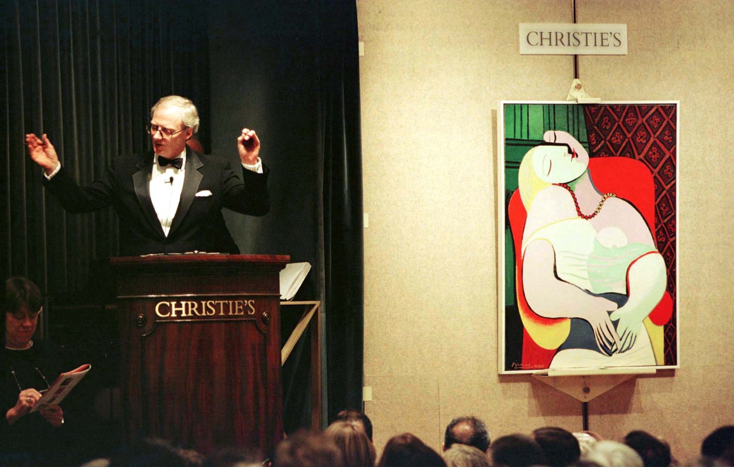 Christie's Auction House Chairman Christopher Burge (L) brings the gavel down on a sale of Picasso's..