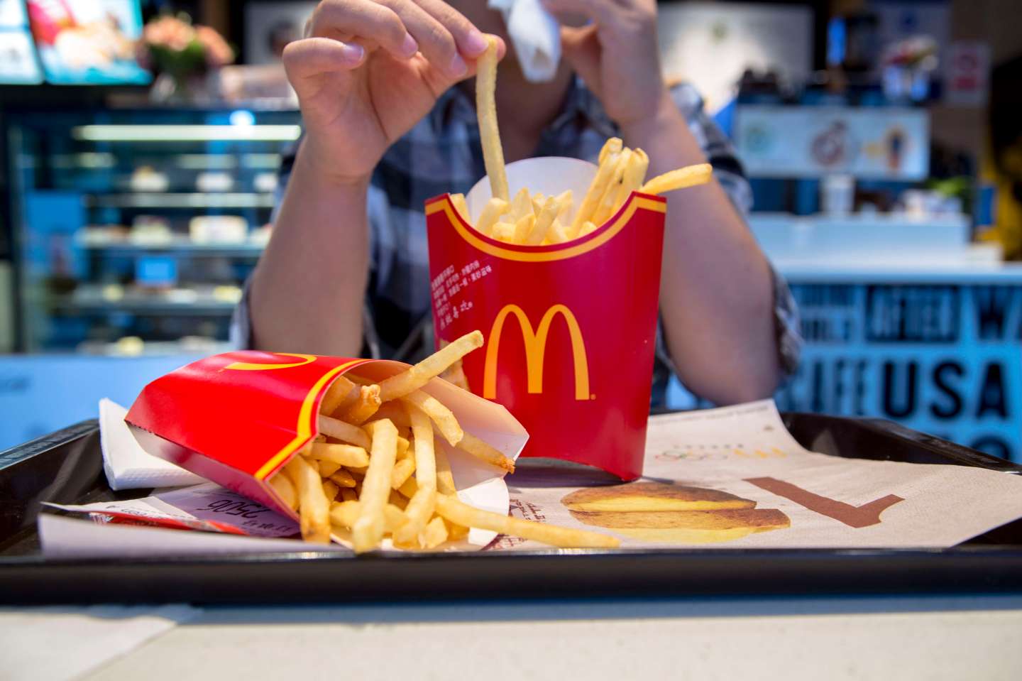 A girl eats fried chips in a McDonald's restaurant