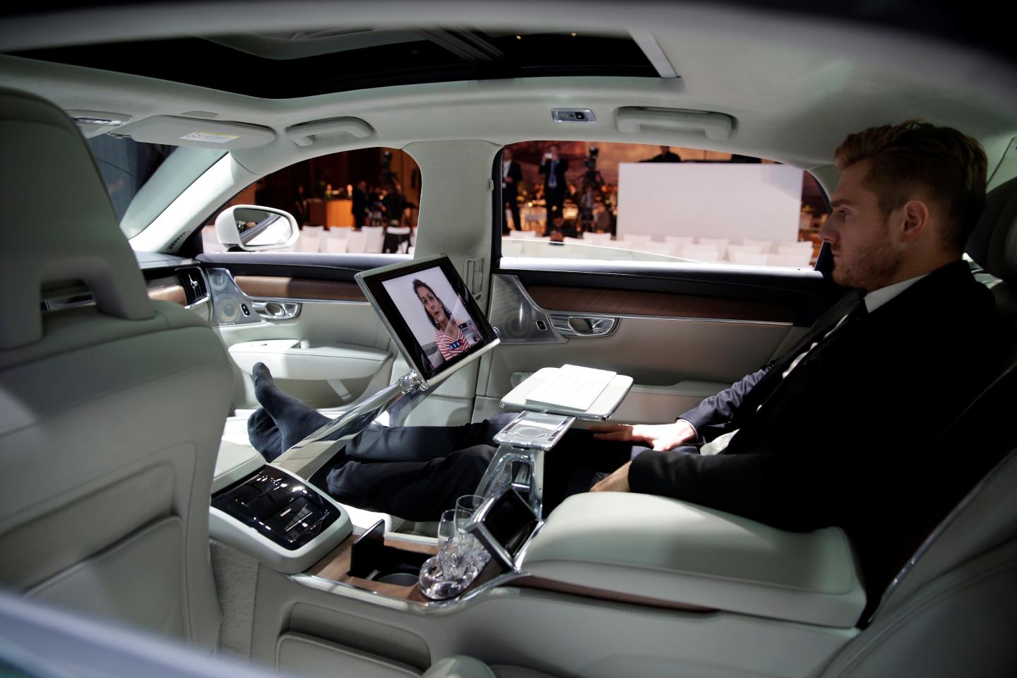 An attendee sits in Volvo's S90 car during the company's news conference in Shanghai