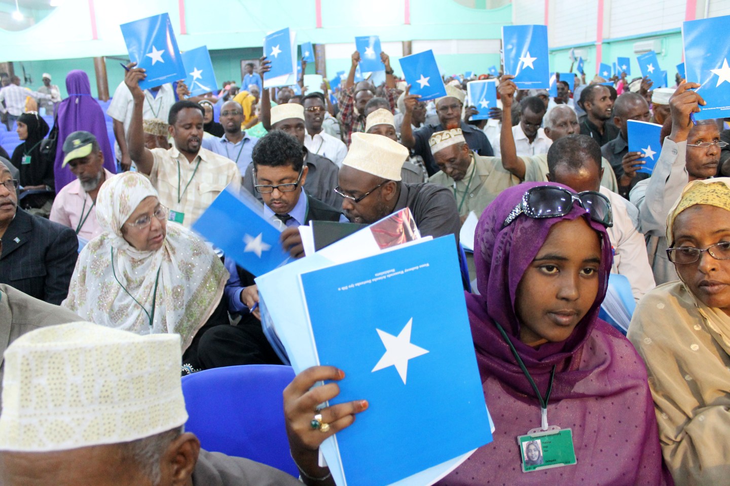 Somali delegates hold up the book of the