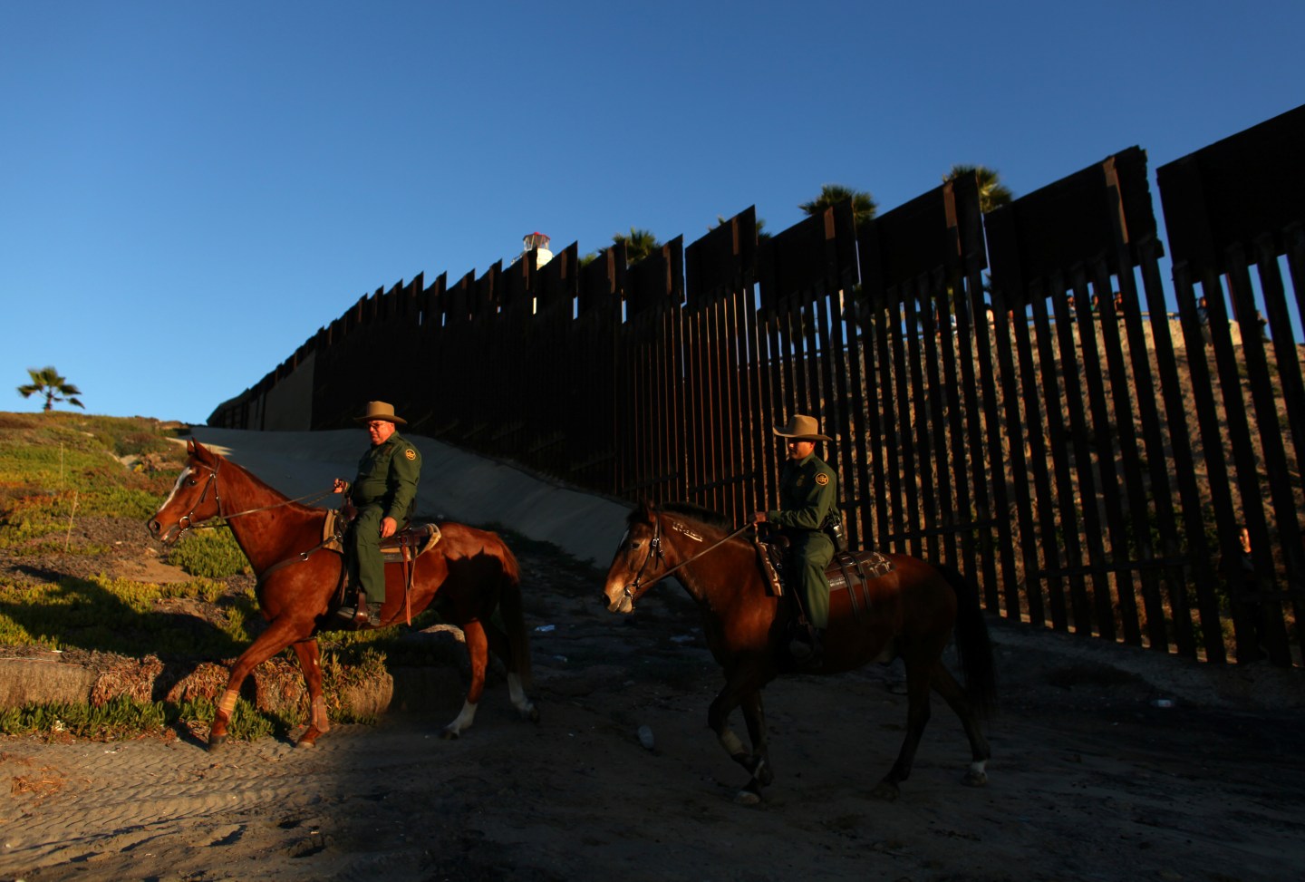 File Photo: U.S. border patrol agents on horseback patrol along the U.S. Mexico border fence near San Diego, California