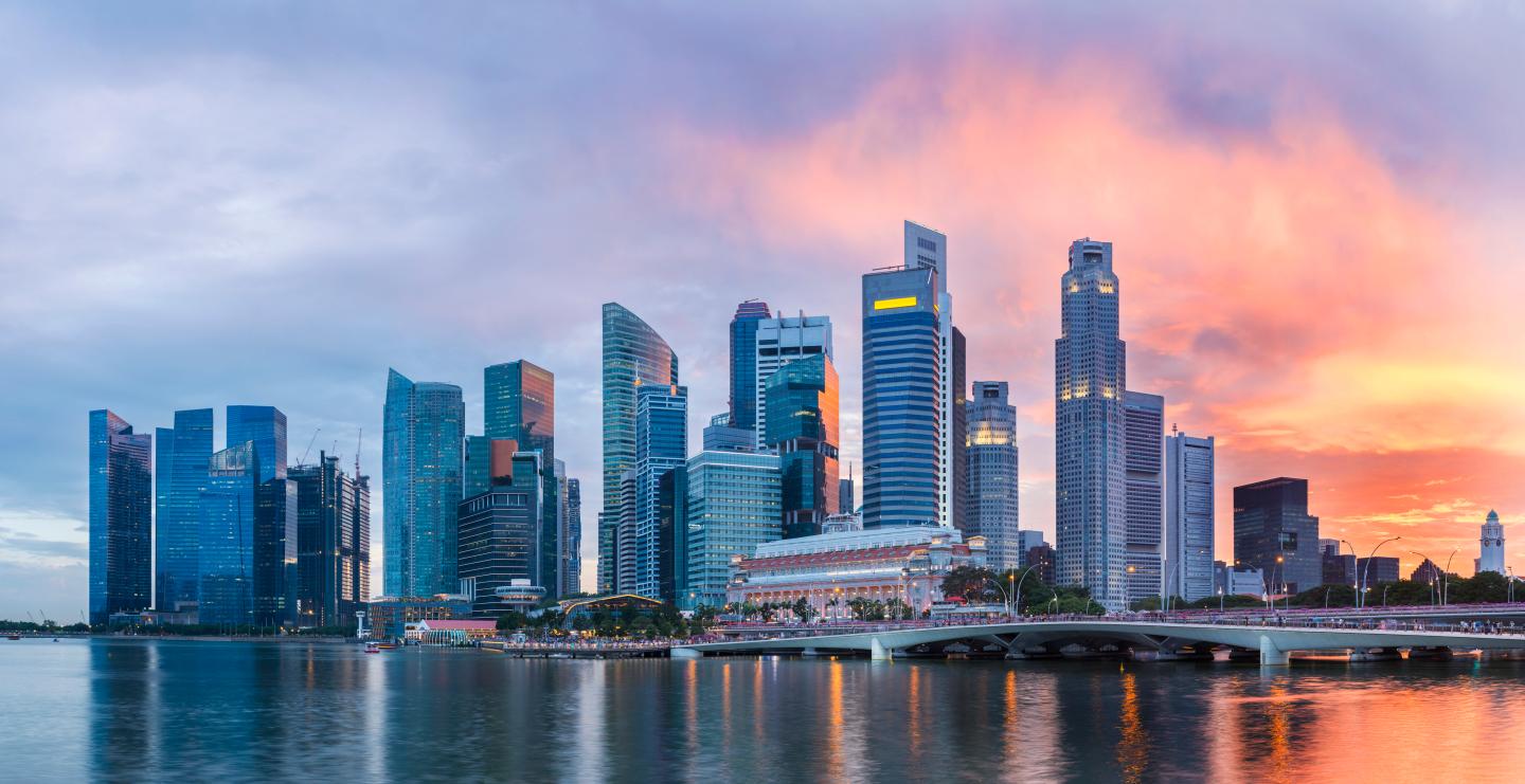 Singapore Skyline at Marina Bay at Twilight with glowing sunset illuminating the clouds