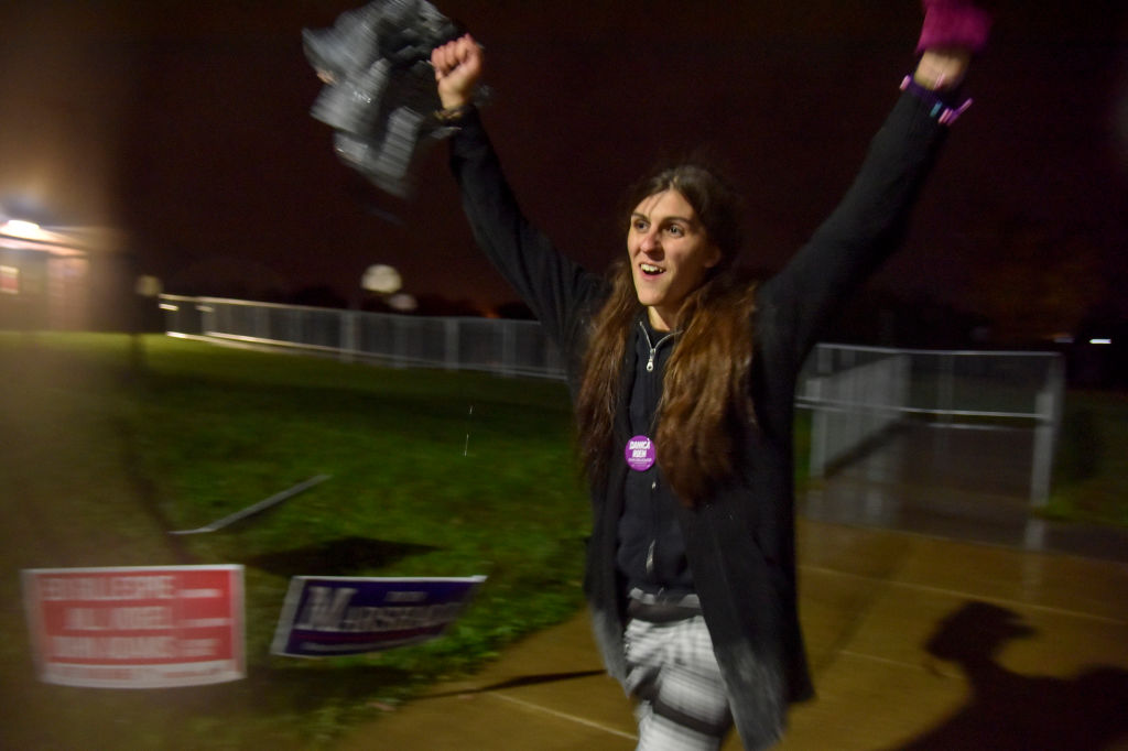 Danica Roem raises her arms in celebration after winning her election