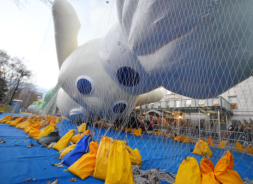 Pillsbury Doughboy balloon for Macy's Thanksgiving Day Parade is inflated and contained by a net