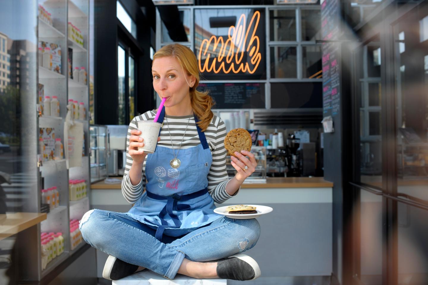 Milk Bar's Christina Tosi poses with milk and cookie in overalls 