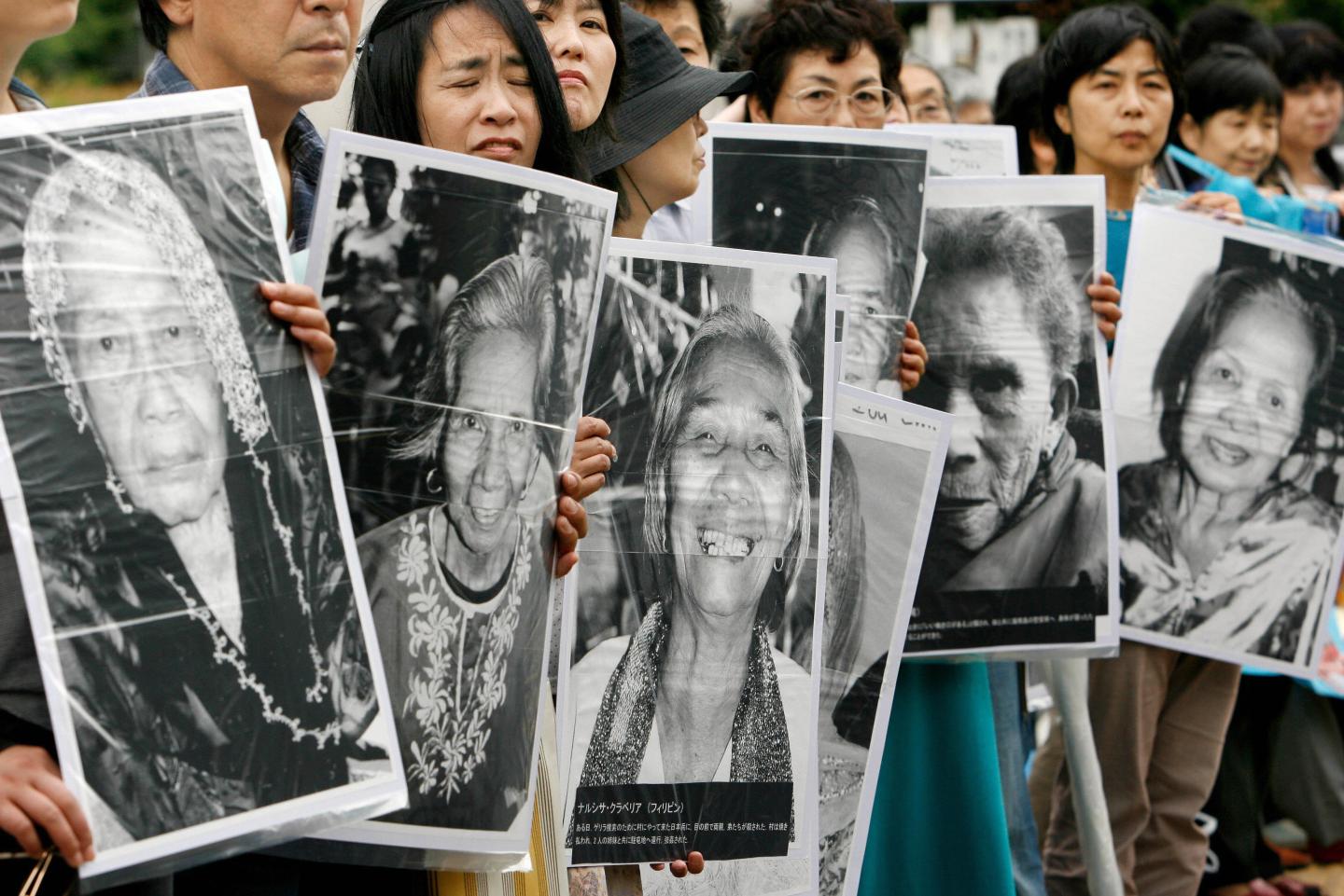 Japanese women hold portraits of Chinese