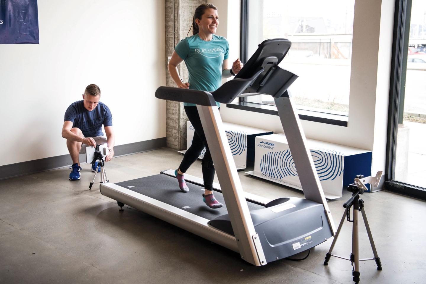 A technician at Brooks records a customer's biomechanics or her running style by using sensors attached to her ankles, shins, and knees.