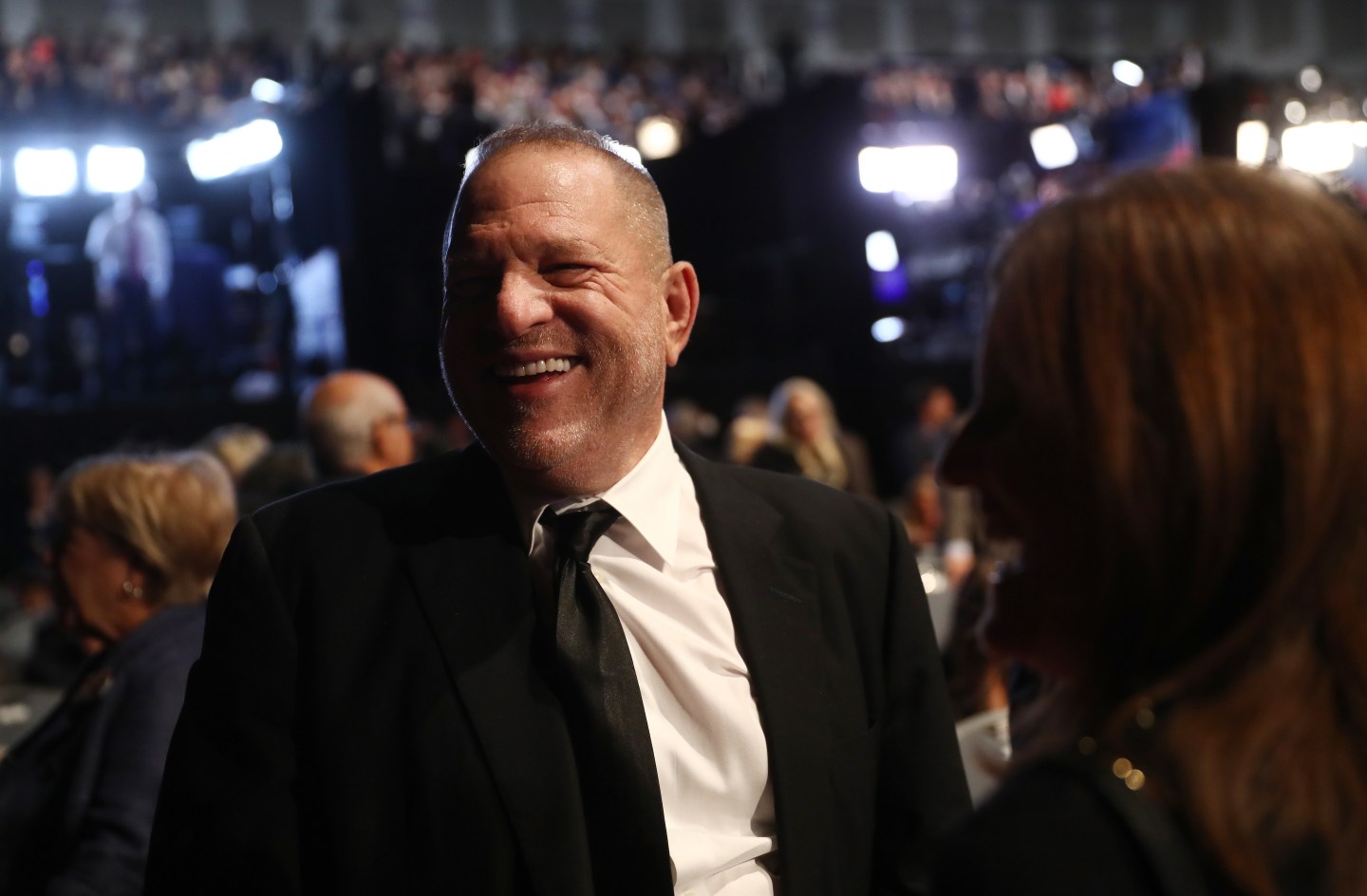 Harvey Weinstein smiles at formal event.