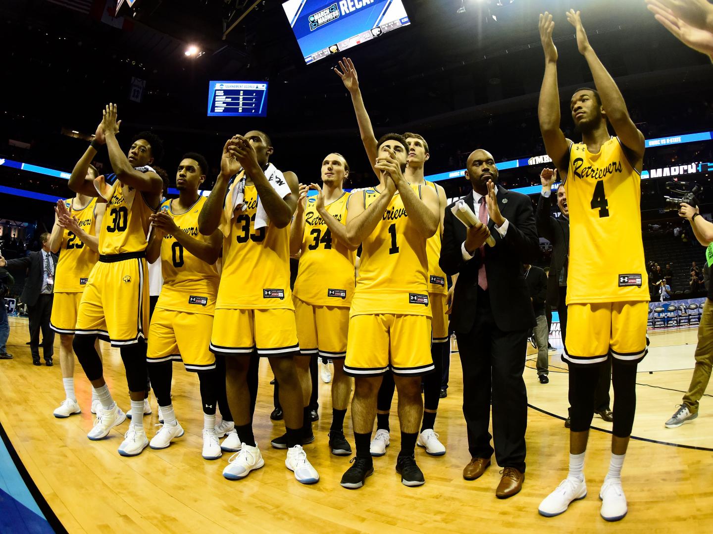 UMBC team claps on basketball court after loss to Kansas State
