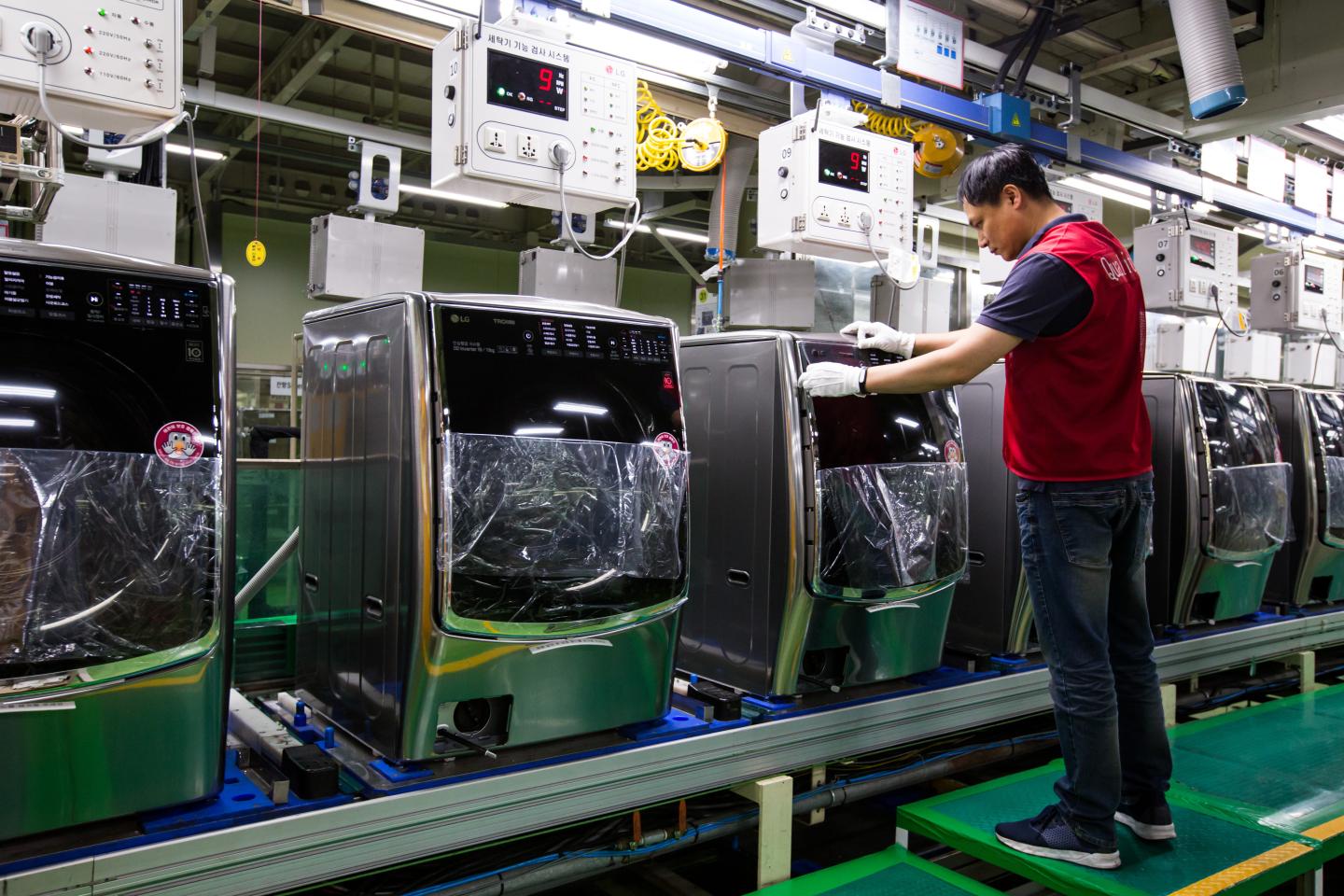 An employee attaches a sticker to an LG washing machine on production line at the company's factory in Changwon, South Korea.