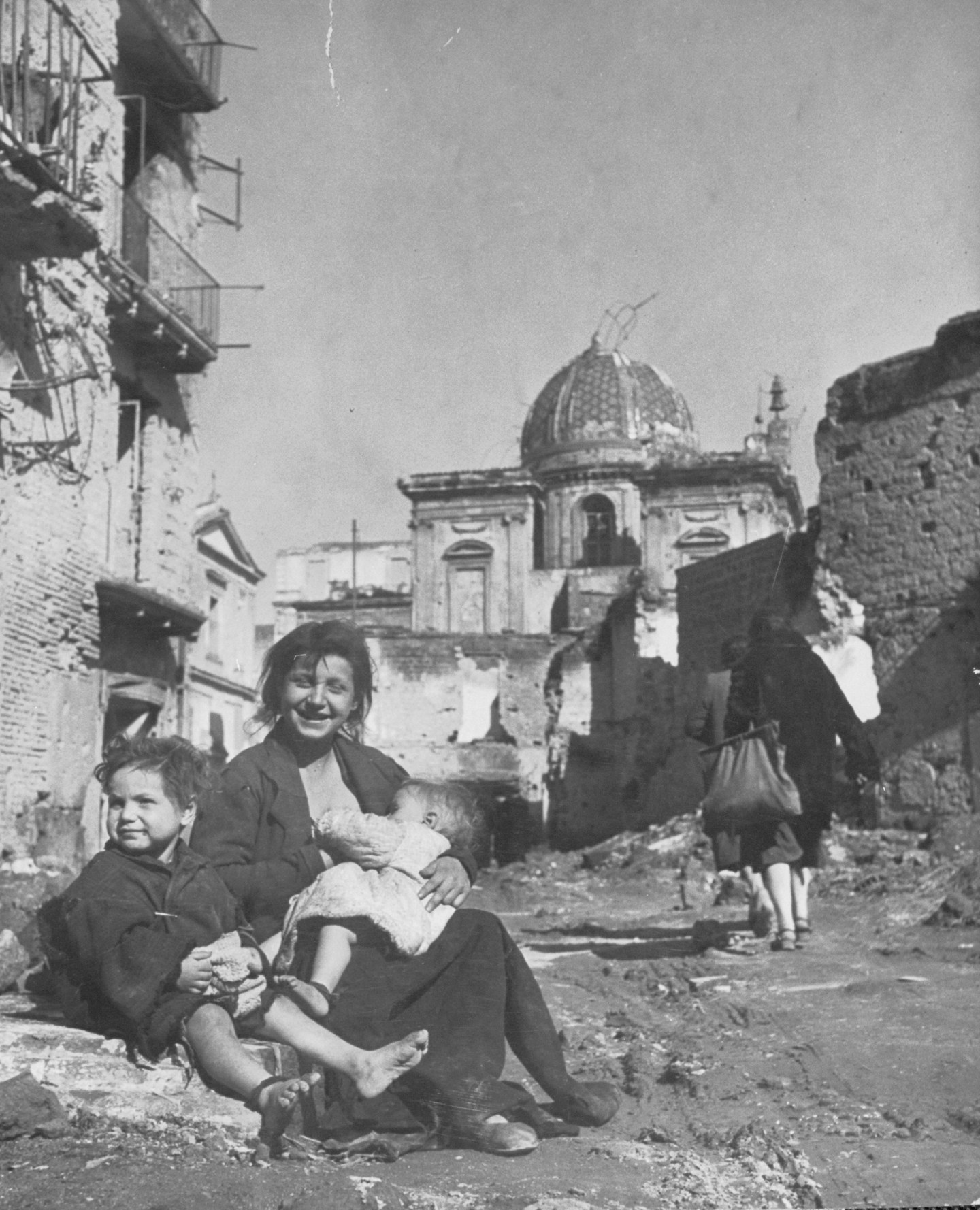 Mother and children living in neighborhood that was bombed in the war.