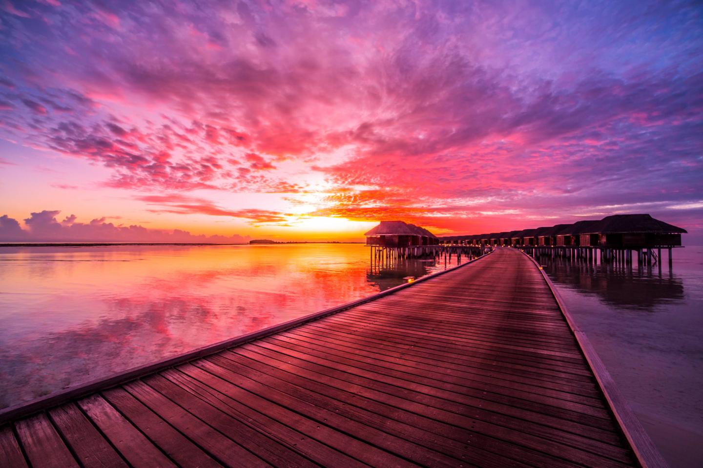  island, water villas resort. Beautiful sky and clouds. Beautiful beach background for summer travel with sun, beach wooden jetty. Summer mood sun beach background concept.