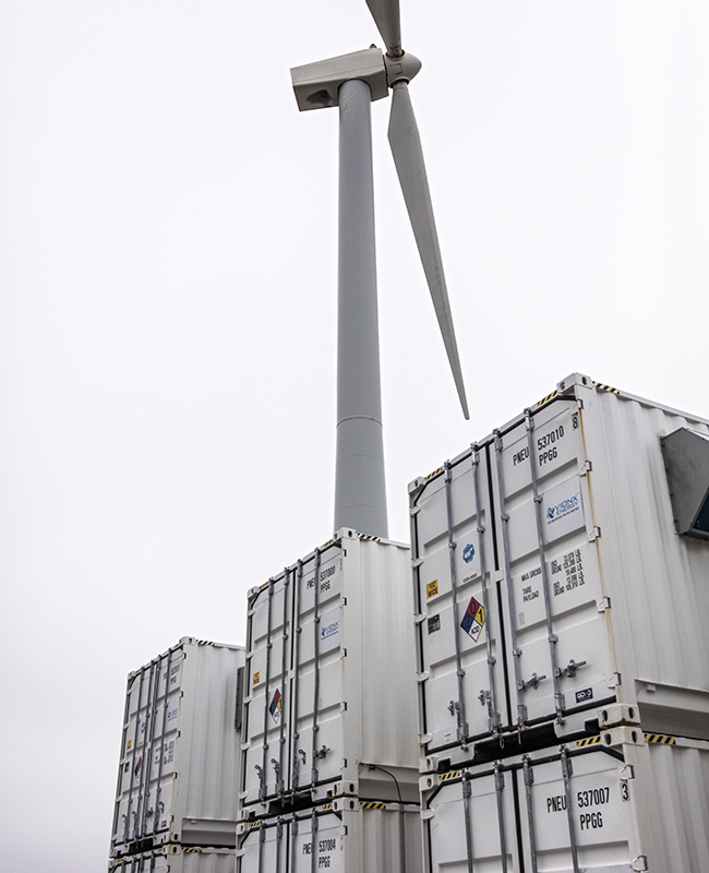 Shipping containers and wind turbine at Vionx