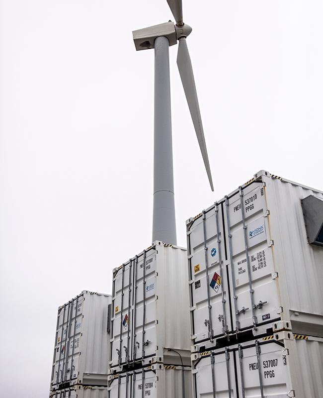 Shipping containers and wind turbine at Vionx