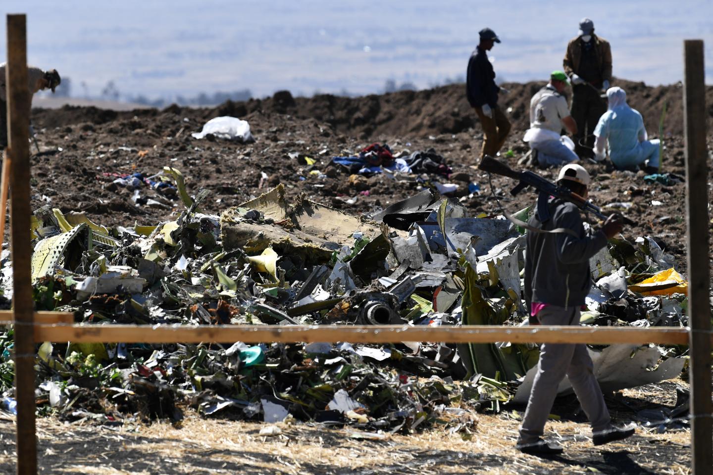 An Oromo man hired to assist forensic investigators walks by a pile of twisted airplane debris at the crash site of an Ethiopian airways operated Boeing 737 MAX aircraft on March 16, 2019 at Hama Quntushele village near Bishoftu in Oromia region. - A French investigation into the March 10 Nairobi-bound Ethiopian Airlines Boeing 737 MAX crash that killed 157 passengers and crew opened on March 15 as US aerospace giant Boeing stopped delivering the top-selling aircraft. (Photo by TONY KARUMBA / AFP) (Photo credit should read TONY KARUMBA/AFP/Getty Images)