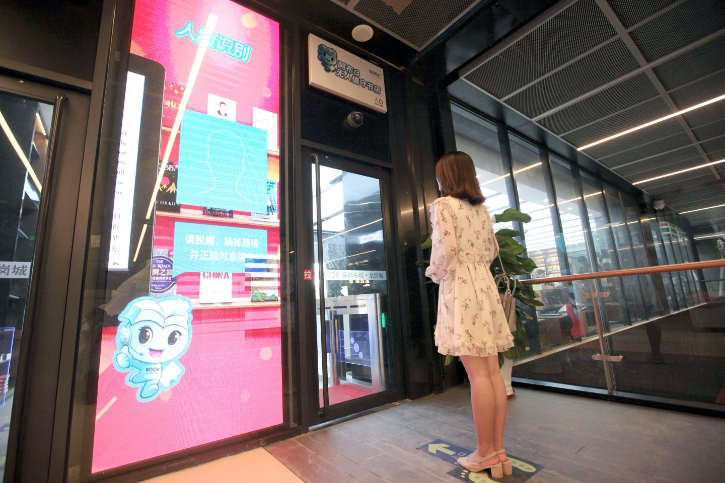 SHENZHEN, CHINA - JULY 17: A customer enters an unmanned bookstore using face recognition system on July 17, 2018 in Shenzhen, Guangdong Province of China. Customers can enter the unmanned bookstore in Shenzhen using facial recognition technology. In addition, the smart bookstore also allows customers to locate books they want and complete payment through WeChat. (Photo by Zhao Yanxiong/Southern Metropolis Daily/Visual China Group via Getty Images)
