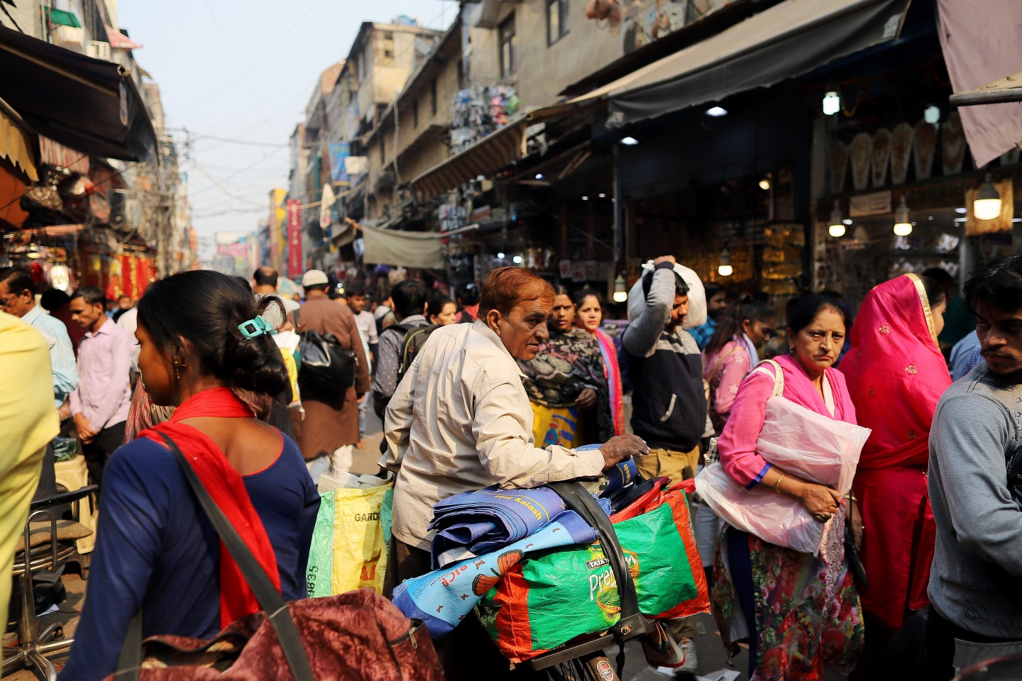 Shoppers walk past stores at Sadar Bazaar in New Delhi, India, on Wednesday, Nov. 20, 2019. In the heart of New Delhi's largest wholesale bazaar, merchants who normally compete with each other have united against a common enemy. The sit-in, which created more chaos than usual among the rickshaws, motorbikes and ox-carts plying the market road, was one of as many as 700 protests against Amazon.com Inc. and Walmart Inc. -- owner of local e-commerce leader Flipkart -- that organizers say took place at bazaars across India on a recent Wednesday. Photographer: Anindito Mukherjee/Bloomberg via Getty Images