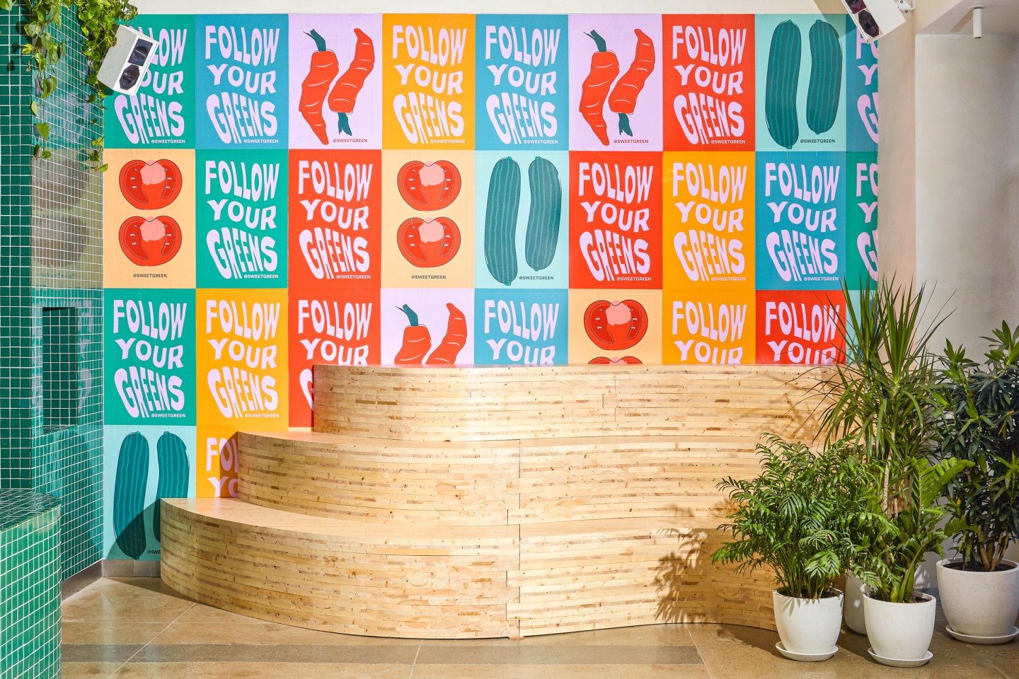 Colorful posters and wooden seating in a Sweetgreen 3.0 store