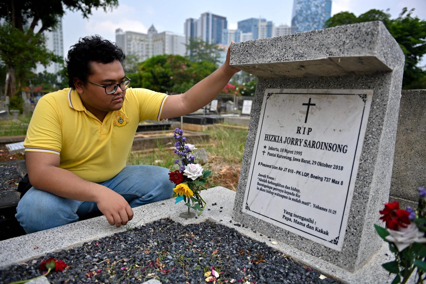 Yoda prays for his best friend who died in the Lion Air plane crash in 2018, at a cemetery in Jakarta October 29, 2019. - Grieving relatives tossed flowers into the sea on October 29 where an Indonesian Lion Air jet crashed a year ago, killing all 189 aboard, after a final accident report pointed to design flaws as a key factor in the disaster. (Photo by BAY ISMOYO / AFP) (Photo by BAY ISMOYO/AFP via Getty Images)