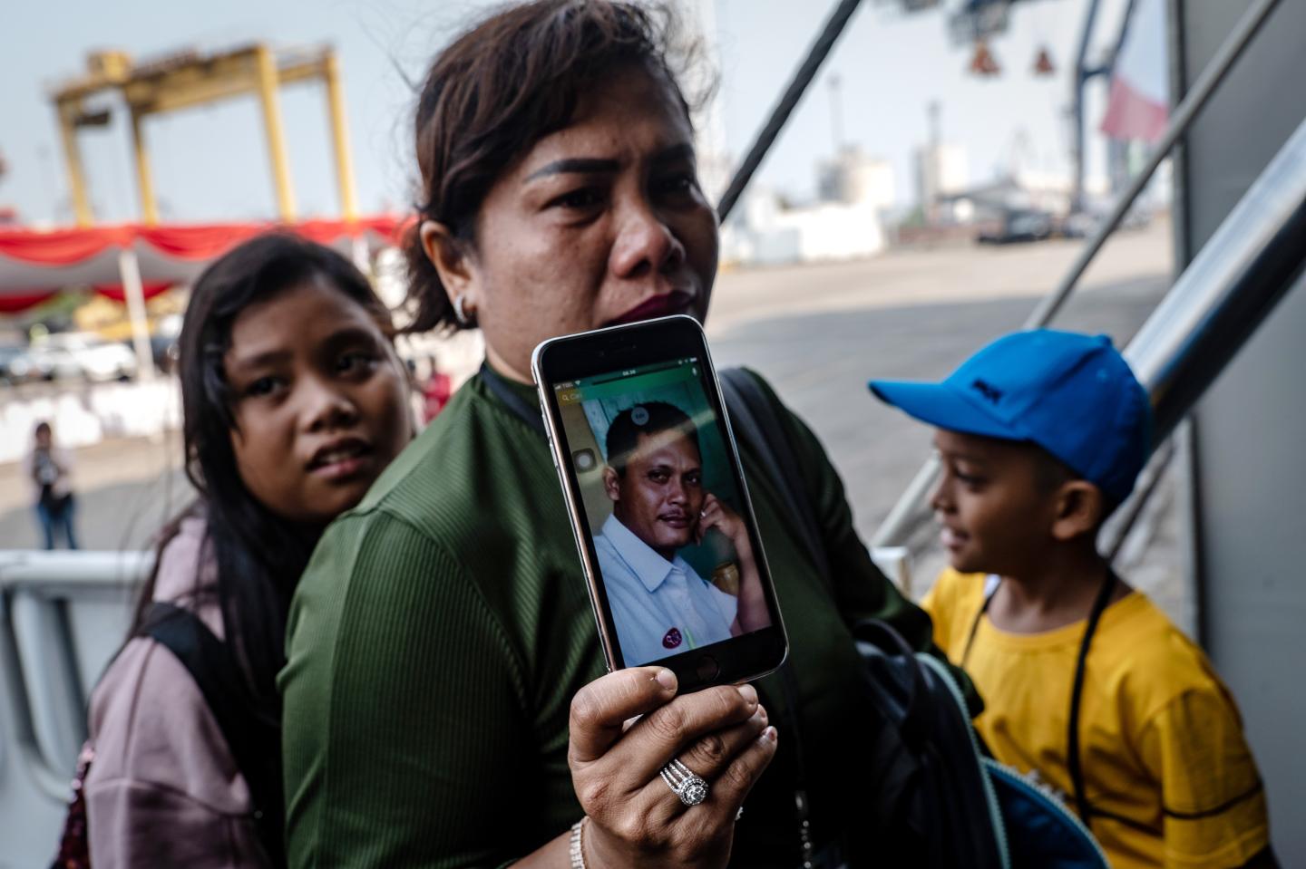 JAKARTA, INDONESIA - OCTOBER 29: Dewi Manik, shows a photo of her husband, Rudy Lumbantoruan, who was a victim on board Lion Air flight JT-610 as she boards the Indonesian Navy ship KRI Semarang to visit the site where the aircraft crashed to mark the disaster’s one-year anniversary at Tanjung Priok port on October 29, 2019 in Jakarta, Indonesia. Indonesians mark one year since the Lion Air crash on Tuesday as investigators said last week that a combination of aircraft design flaws, inadequate training and maintenance problems were the cause of the crash which killed all 189 people on board. Indonesian authorities added that the pilots of the Boeing 737 Max 8 plane were overwhelmed in responding to a malfunctioned flight-control system which led to its crash on October 29, 2018. (Photo by Ulet Ifansasti/Getty Images)
