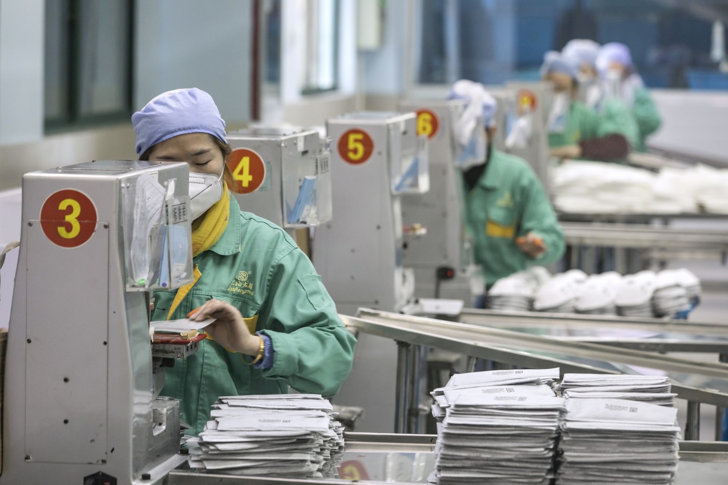 Employees work on the assembly line to make protective masks at a factory operated by Dasheng Health Products Manufacturing Co. in Shanghai, China, on Friday, Jan. 31, 2020. People across the globe are stockpiling facial masks to protect themselves from the new coronavirus, depleting online malls and store shelves from California to Beijing. Photographer: Qilai Shen/Bloomberg via Getty Images