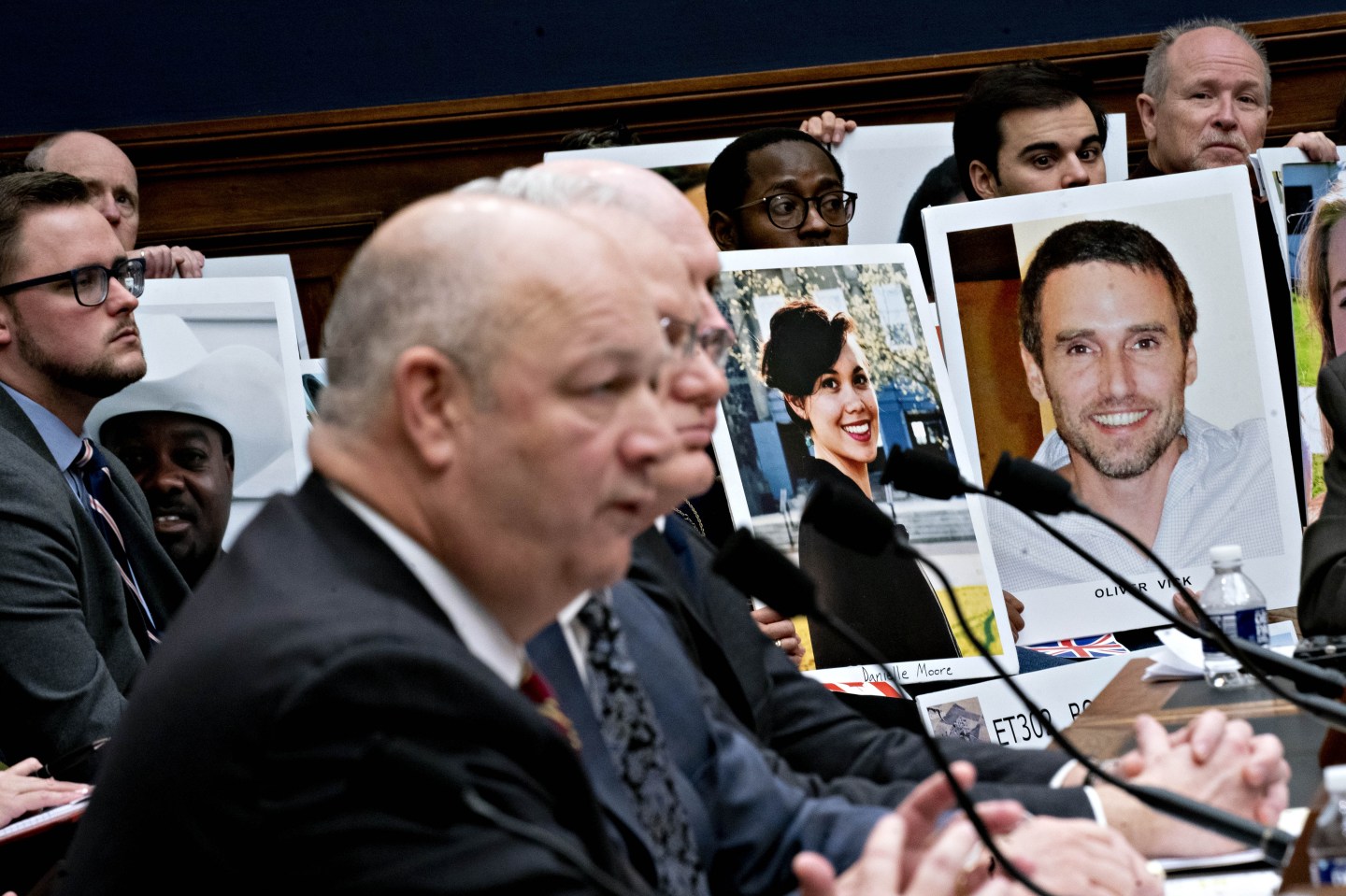 Family members of Boeing Co. 737 Max crash victims hold photographs as Stephen Dickson, administrator of the Federal Aviation Administration (FAA), center left, speaks during a House Transportation and Infrastructure Committee hearing on the Boeing 737 Max aircraft in Washington, D.C., U.S., on Wednesday, Dec. 11, 2019. Two 737 Max jetliners crashed in a five-month span killed 346 people. The first, in October 2018, was a Lion Air flight that went down in the Java Sea. An Ethiopian Airlines jet crashed in Ethiopia in March. Photographer: Andrew Harrer/Bloomberg via Getty Images